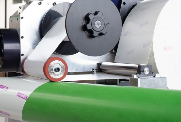 Application automatique du ruban adhésif sur un manchon flexographique