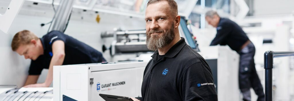 Technicien GARANT réalisant une maintenance sur une machine de production.